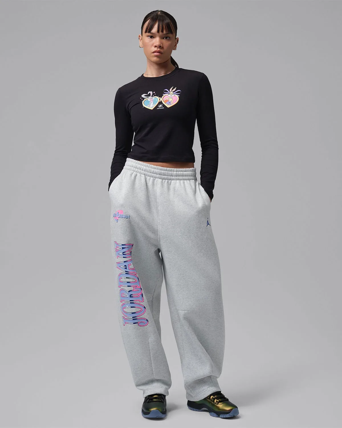 full-body on-foot, pair of iridescent gold low-top sneakers with black crop top and grey sweatpants, WMNS Space Jam