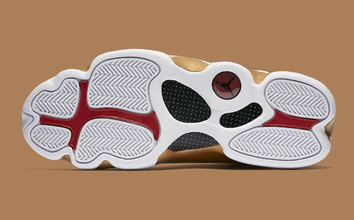 Outsole of white sneaker with red accents, black perforated panels and a red circular Jumpman badge, Defining Moments Pack
