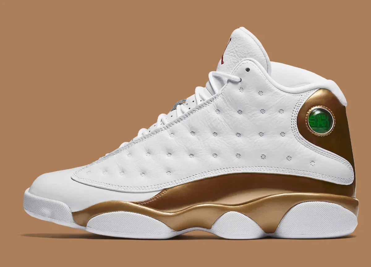 Lateral view of white sneaker with glossy gold midsole panel and green circular heel badge, Defining Moments Pack