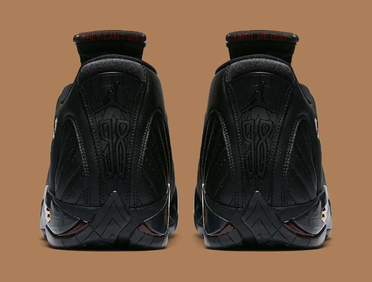 Heel view of two black sneakers with red 'They can't win' and 'Until we quit' text on tongues, Defining Moments Pack