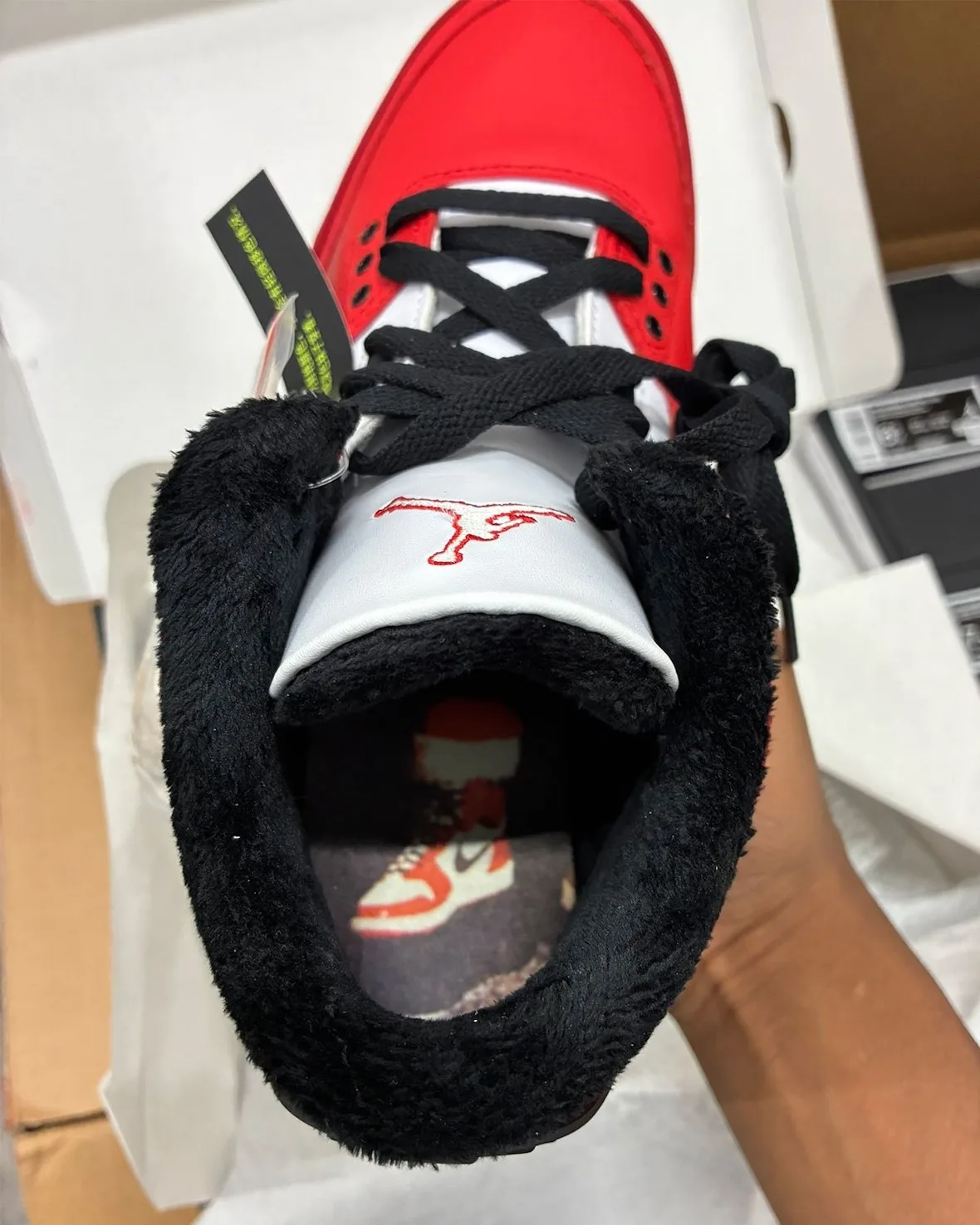 Detail looking into the shoe, black fleece lining, white Jumpman tongue, insole print of a red and white sneaker, Santa
