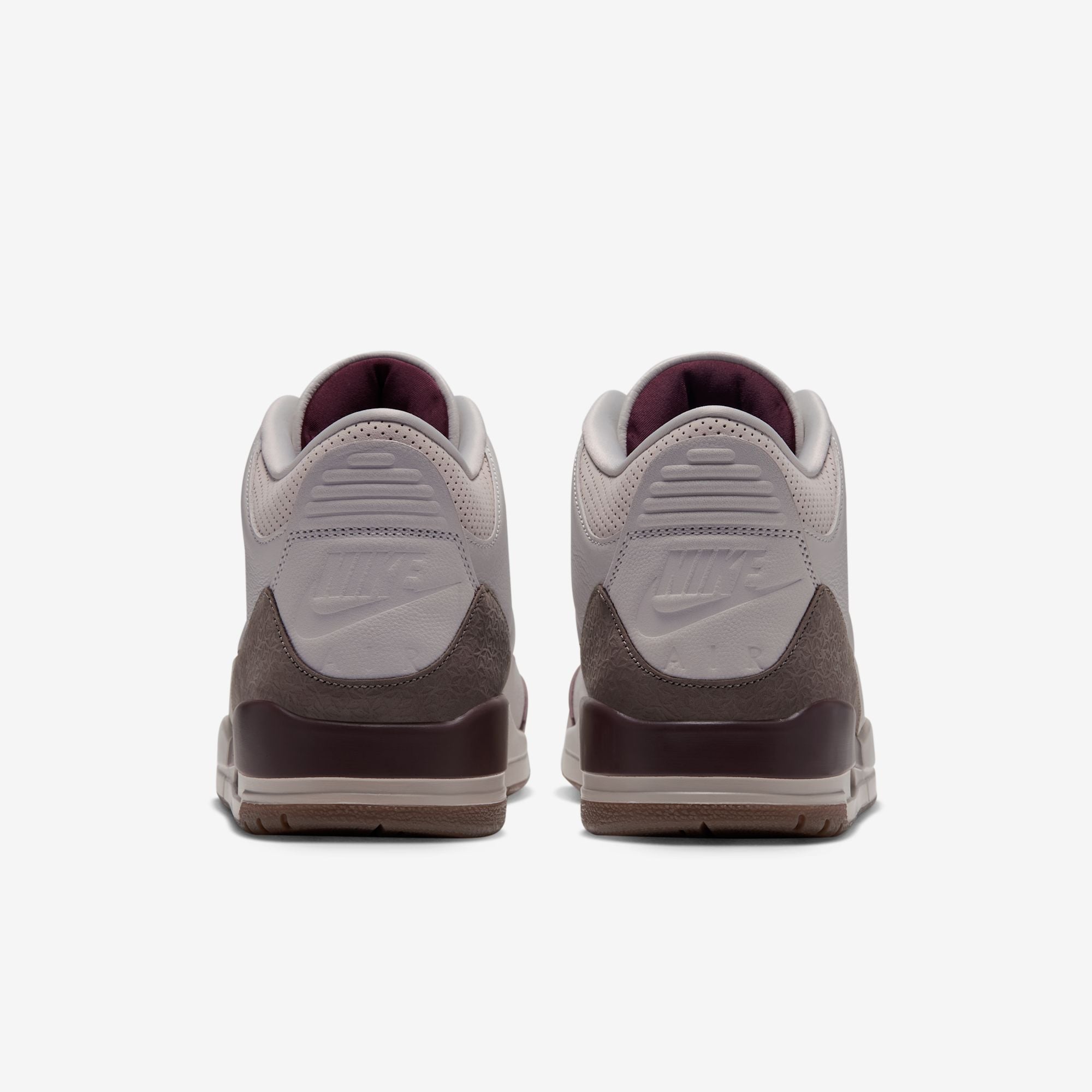 heel view of pair showing embossed Nike Air text and burgundy sockliner lining, Middle East