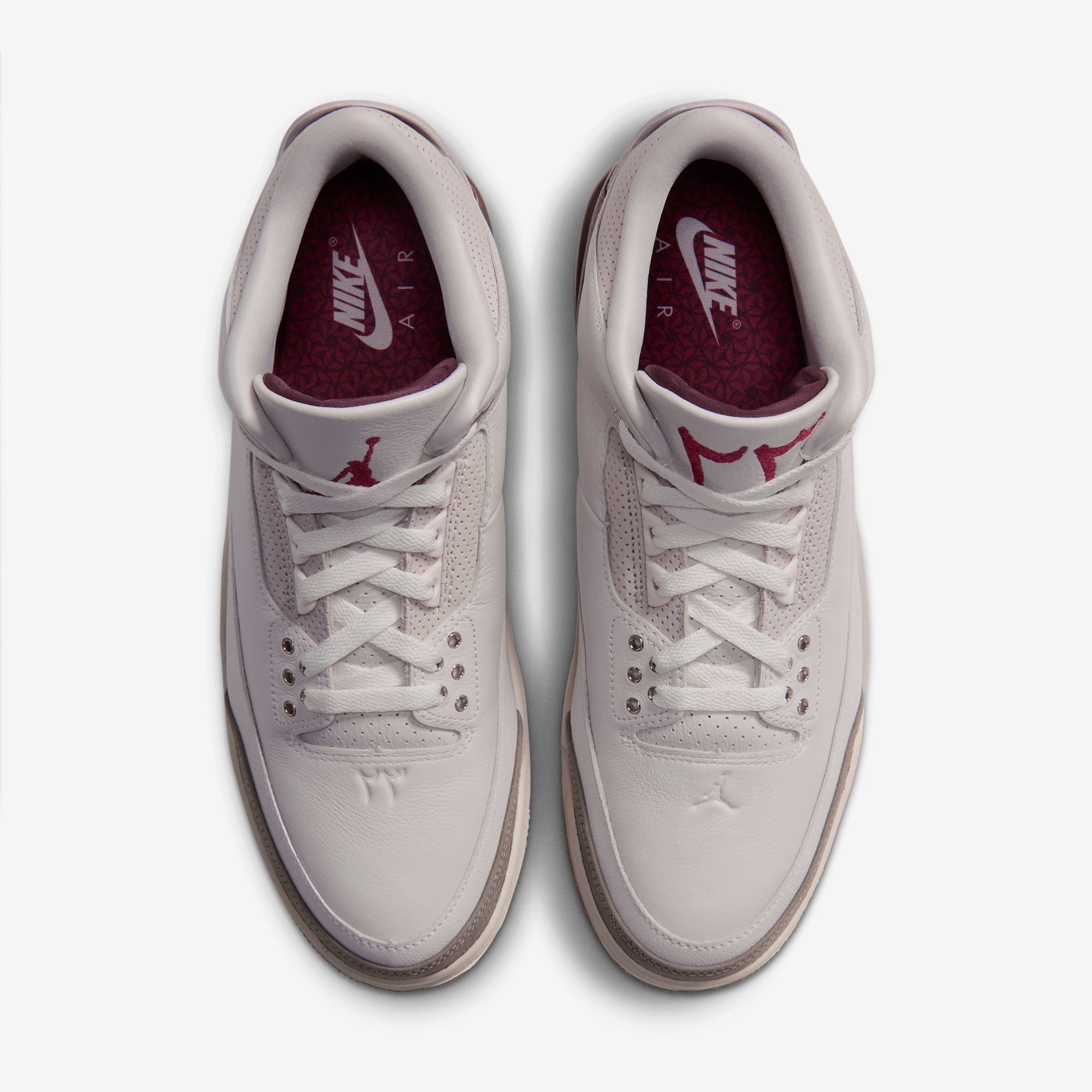 top-down pair view showing burgundy floral-print insoles and Nike Air branding, Middle East