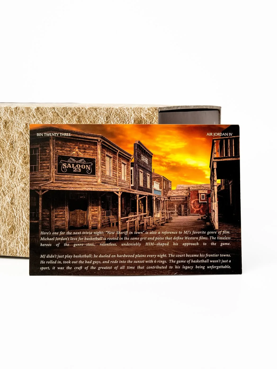 Postcard of Western street at sunset, Saloon 23 sign, text, propped against box, Bin23