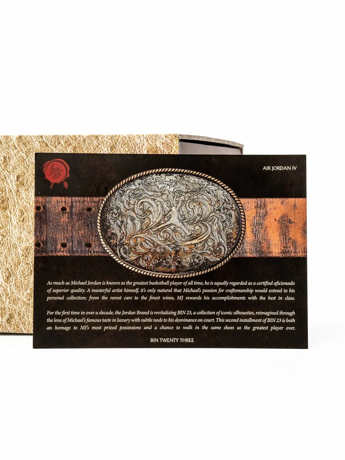 Insert card with ornate belt buckle on leather belt, red bin23 seal and paragraph text, Bin23