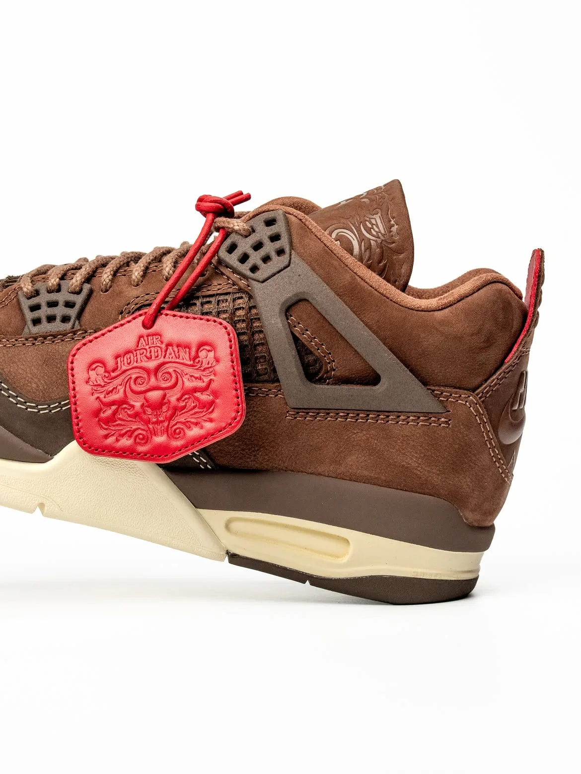 Detail of lateral heel half, red Air Jordan tag, dark brown cage and cream air window, Bin23