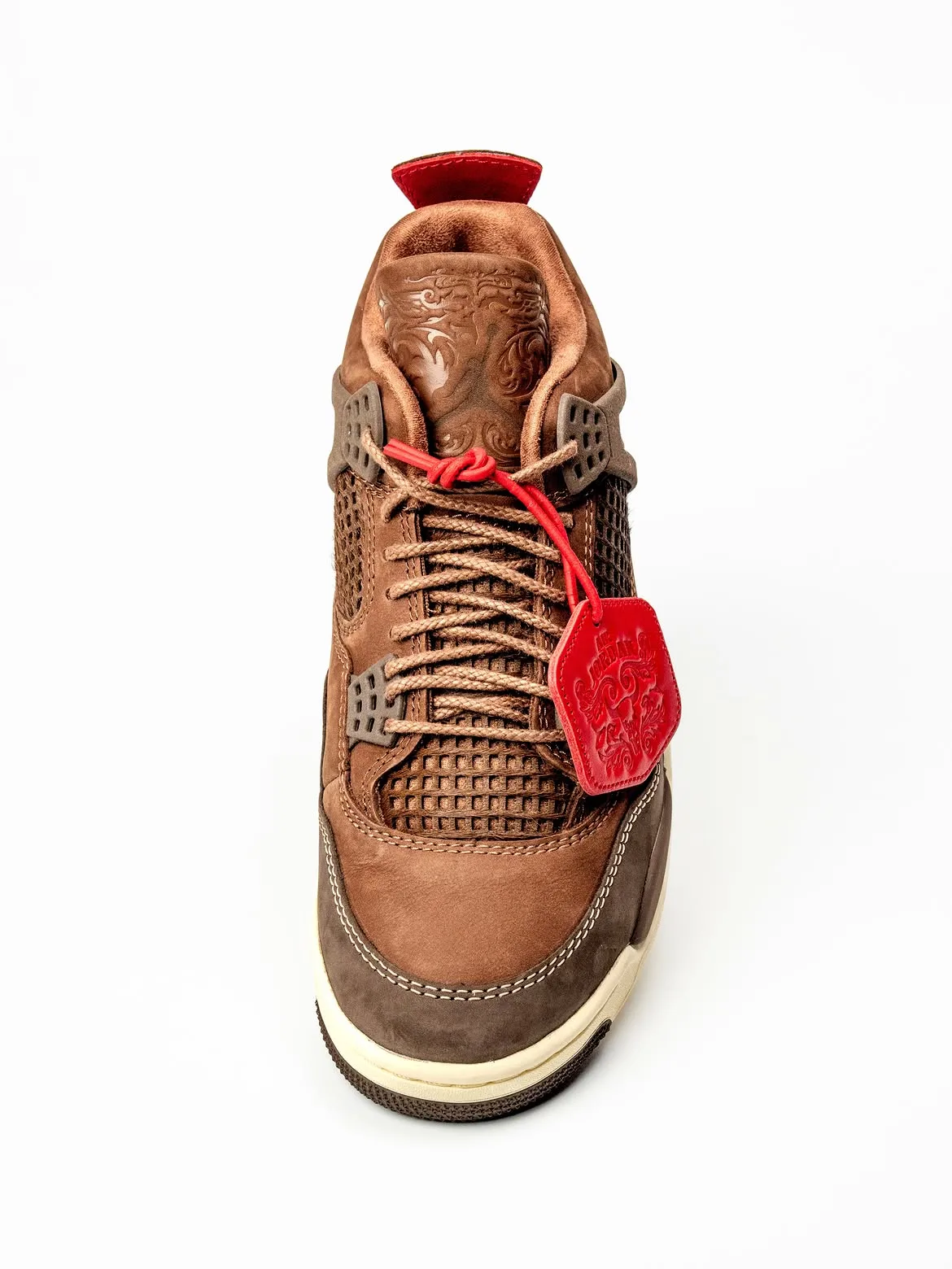 Top-down toe view, brown laces, red cord and hexagonal tag, laser-etched tongue, Bin23