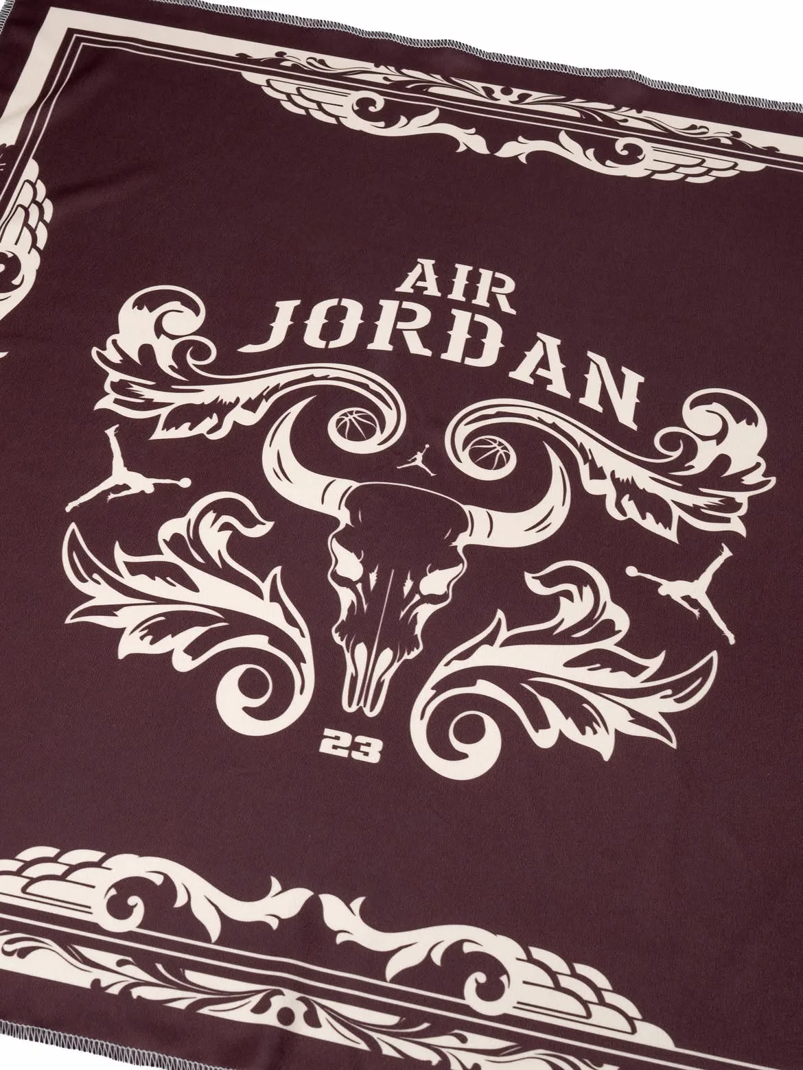 Detail of cream-on-maroon Air Jordan print with horned skull, flourishes and 23, Bin23