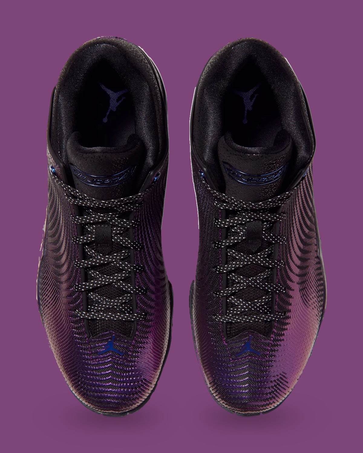 Top-down view of pair, black laces, blue Jumping logos on toes and tongue, purple backdrop, Amethyst