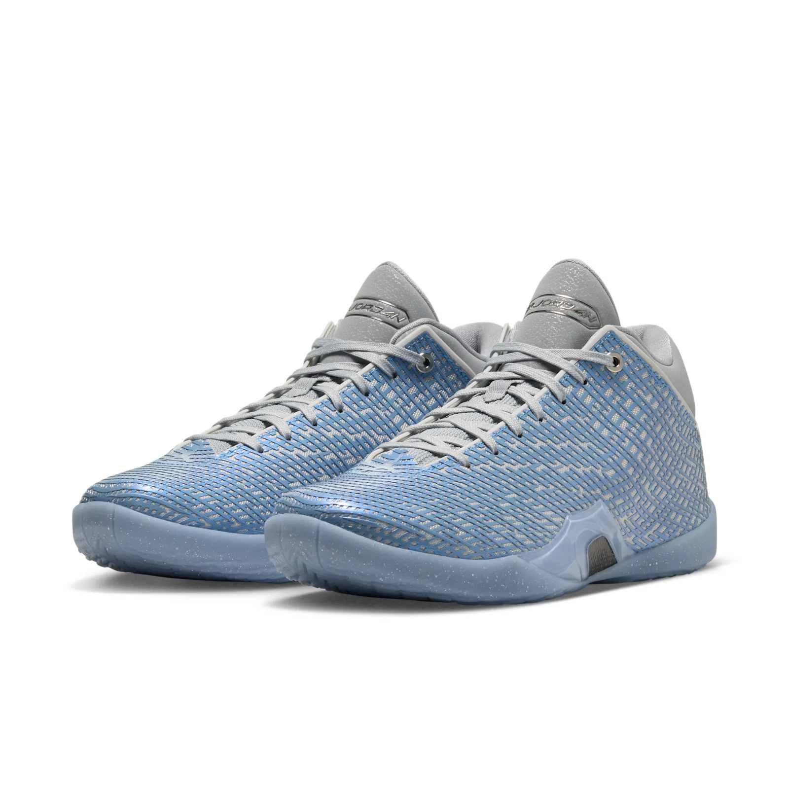 Pair at a three-quarter angle, light blue patterned uppers, grey laces, speckled translucent soles, Space Jam