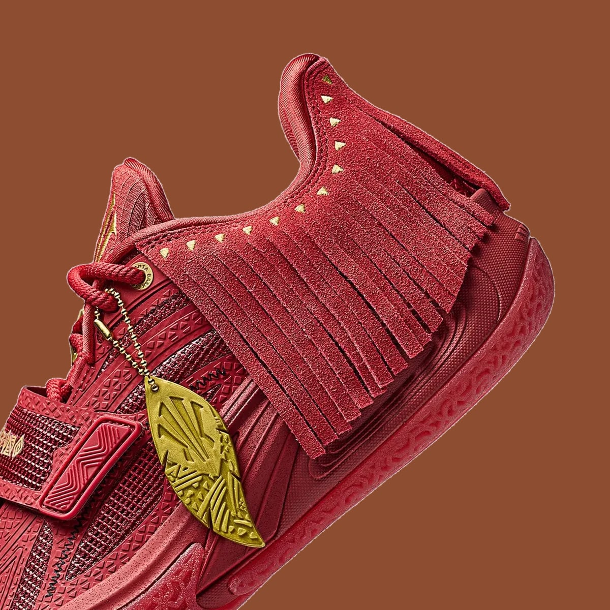 Detail of lateral heel, red fringe, gold feather charm and textured red sole, Red