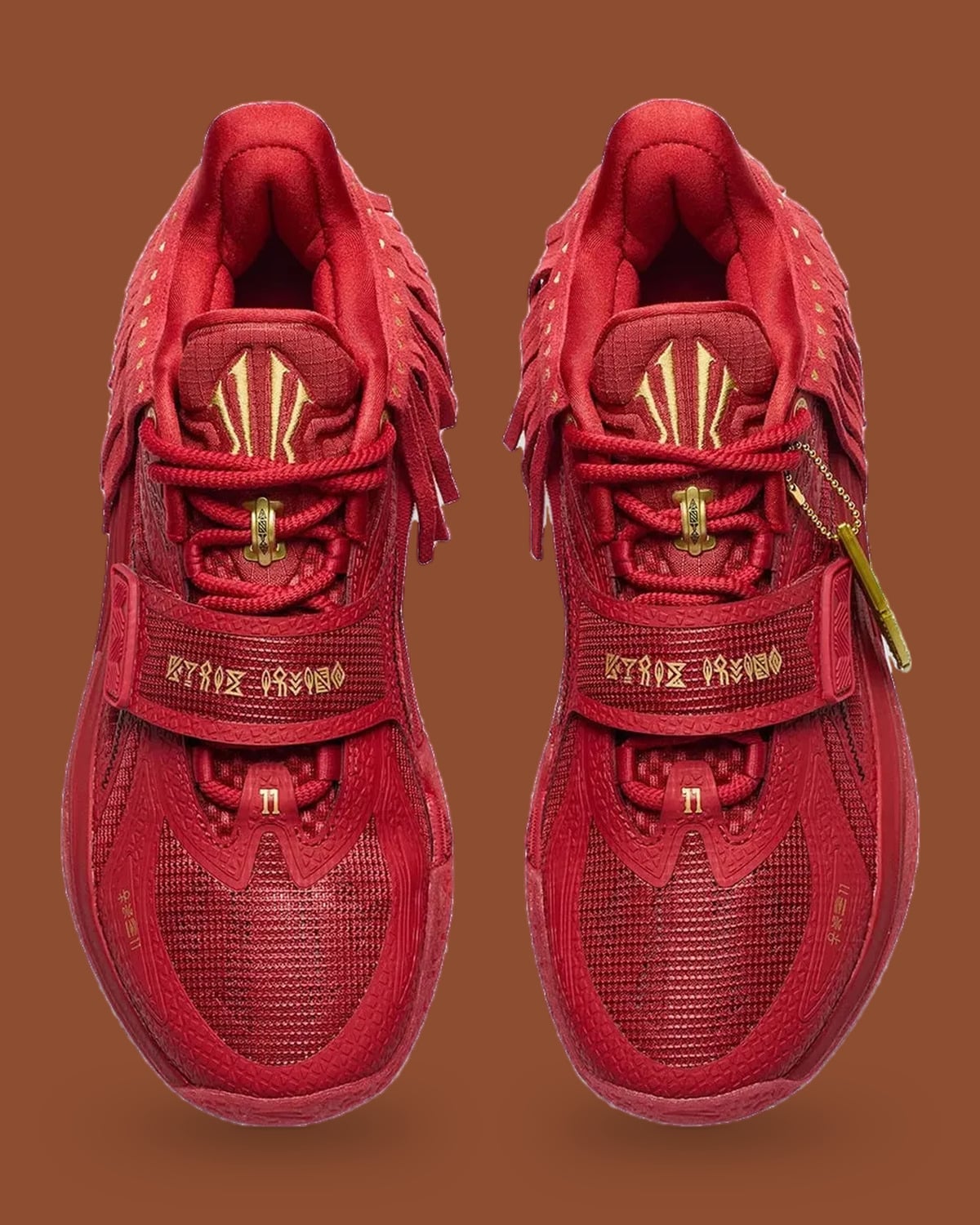 Top-down pair, red mesh with strap bearing gold glyph text and gold logo, Red