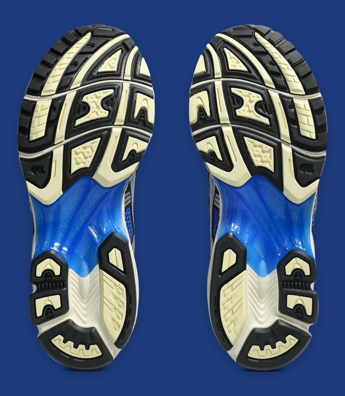Outsole view of the pair, black and cream lugs with a blue gel heel section, Illusion Blue