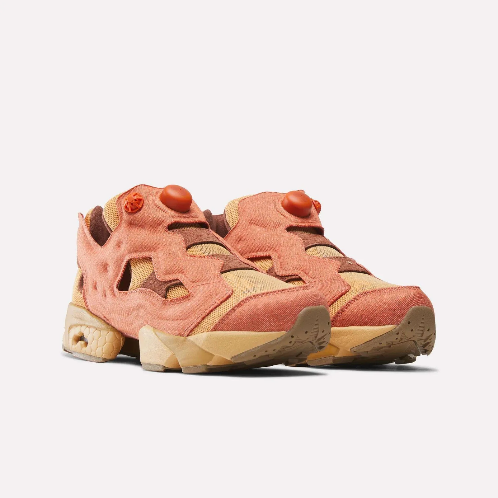 Front three-quarter view of pair, terracotta overlay, orange pump buttons, brown outsole, Aang