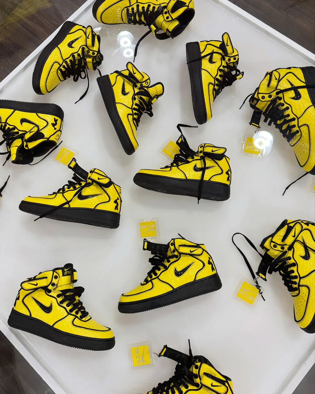 Top-down spread of yellow and black mids on a white surface with clear "It's us" tags, Force 1 Mid