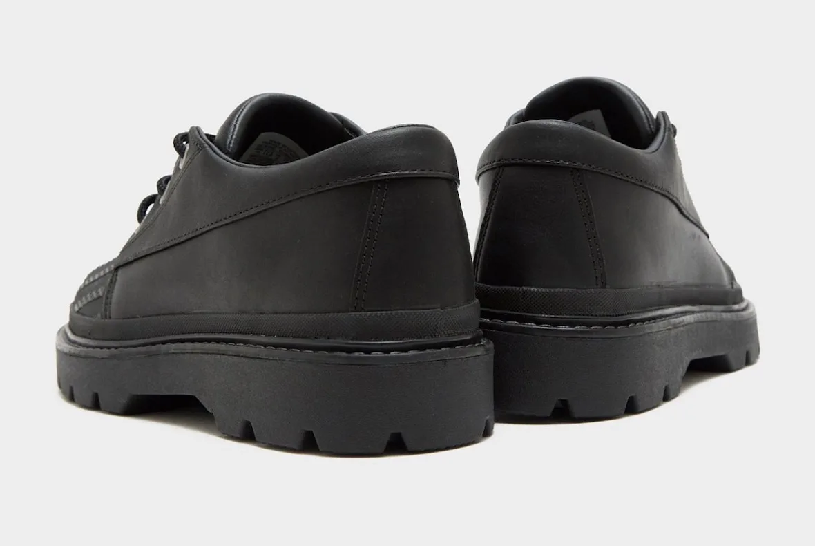 Heel view of black leather pair, stitched heel tabs, chunky lugged black soles, Bronco Boot Low