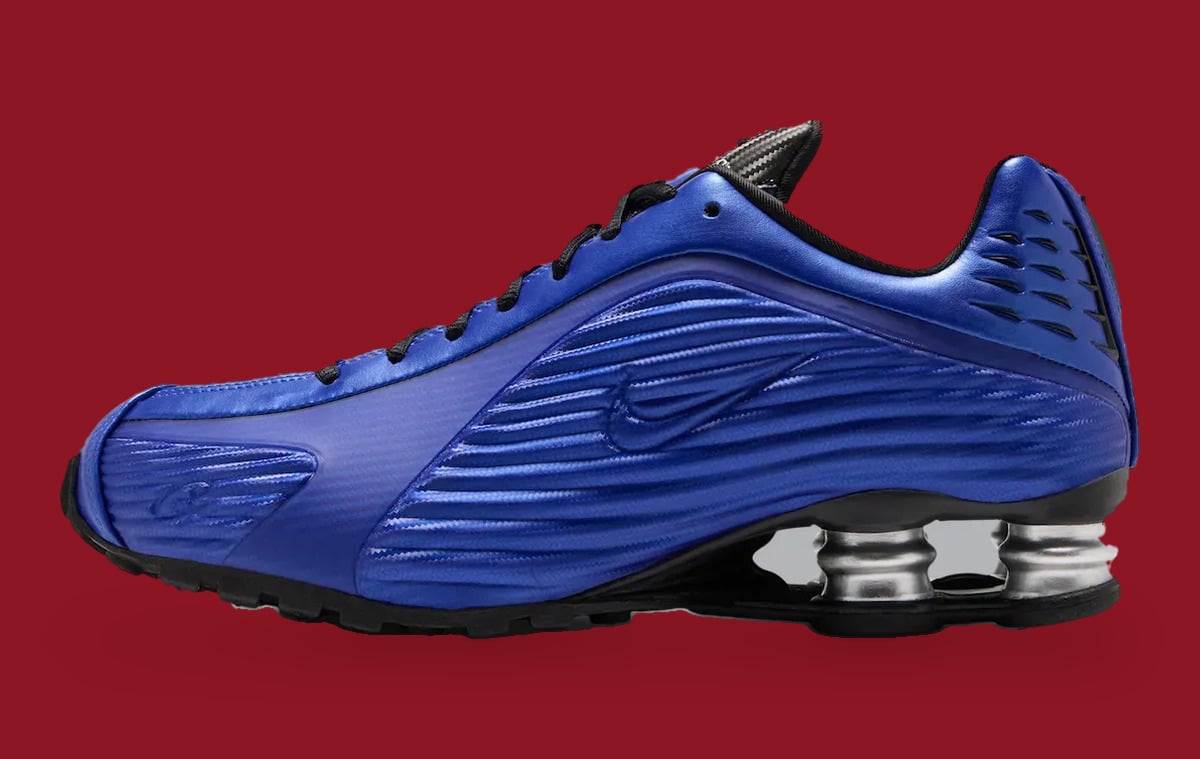 Lateral view: metallic blue ridged upper with tonal swoosh, black laces, silver heel springs, Game Royal