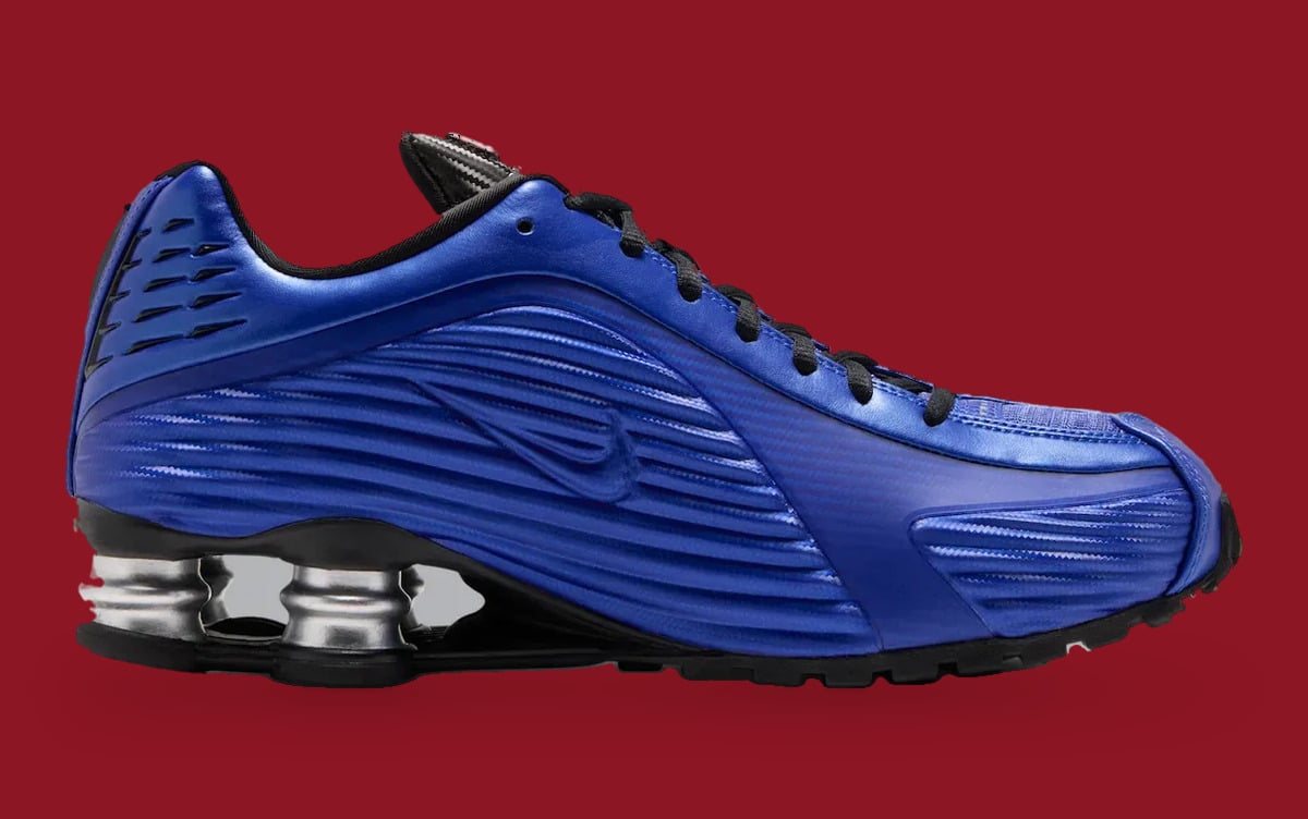 Medial view: ribbed blue upper with embossed swoosh, black laces and sole, silver heel springs, Game Royal