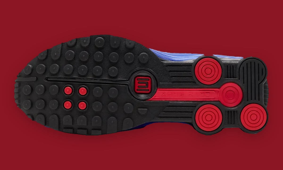 Outsole view: black studded sole with red circular heel pods and red logo in the centre, Game Royal