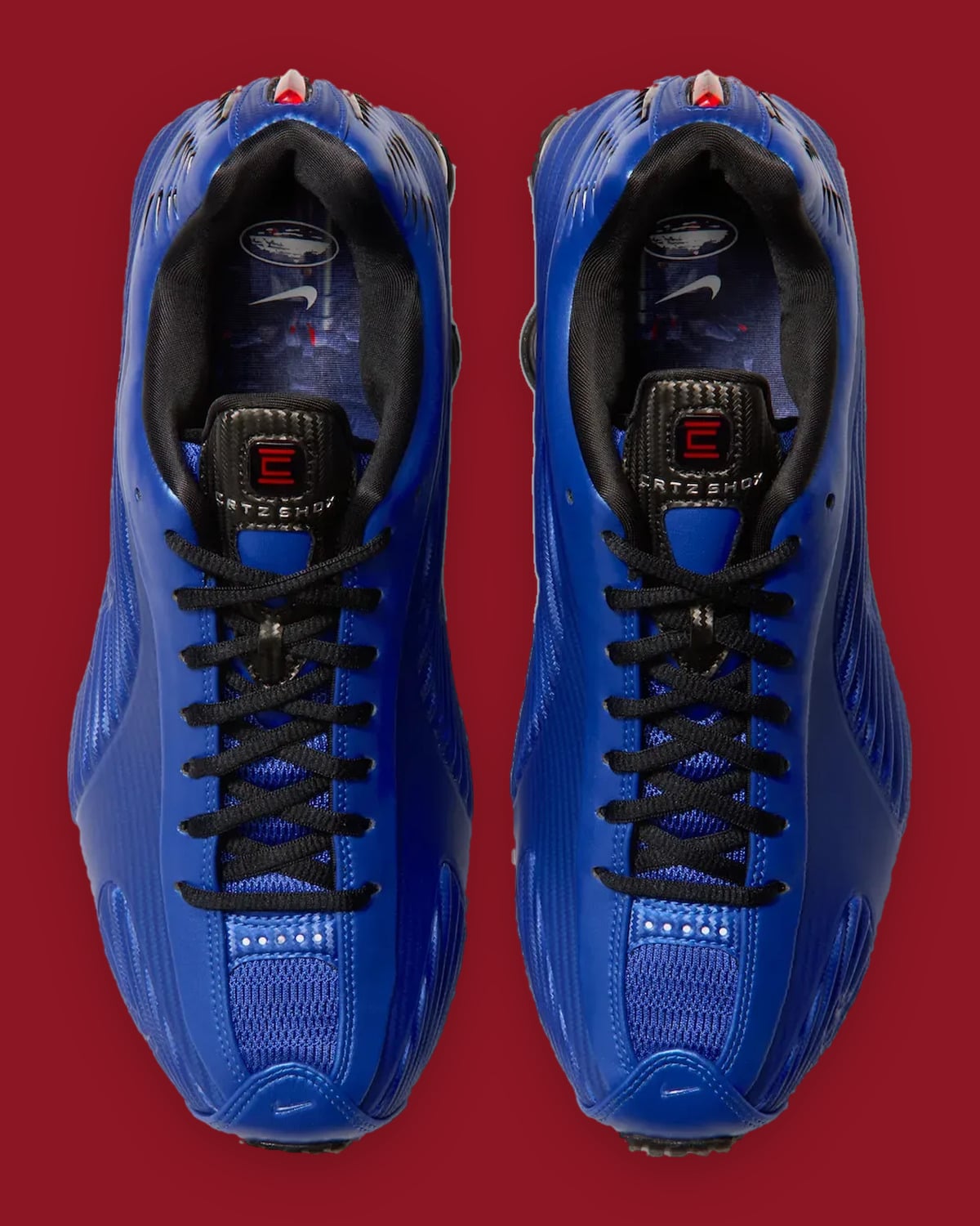 Top-down view of pair: blue uppers, black laces, carbon-look tongues with red logo, Nike insoles, Game Royal