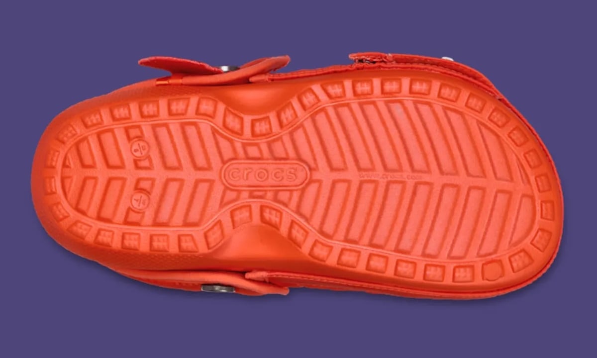 Outsole view in orange with crocs logo and tread pattern on purple background, Classic Lined Clog