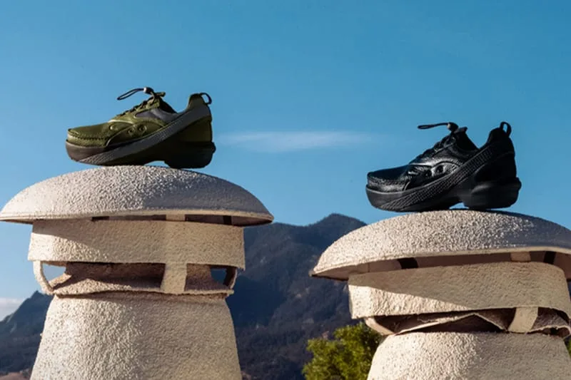 Pair of olive and black shoes on top of pale mushroom-shaped sculptures against a blue sky, x Kiko Kostadinov