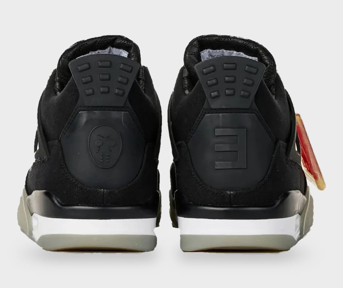 Heel view of pair; black canvas, grey heel tabs with mask and E logos, translucent sole, StockX LISTED Collection
