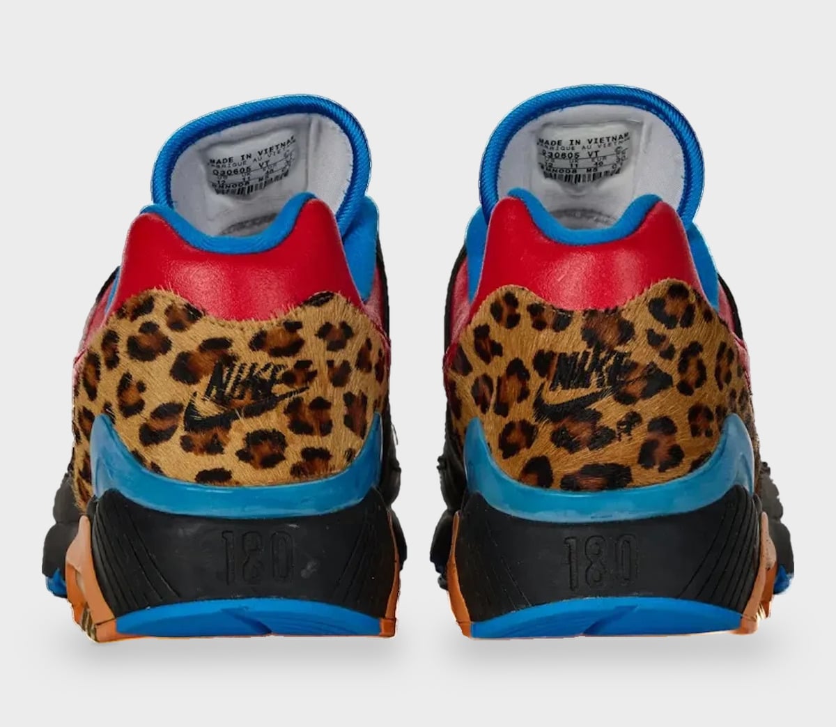 Heel view of pair; leopard-print panels, red collar, blue trim, Nike logo and 180 on black heel, StockX LISTED Collection