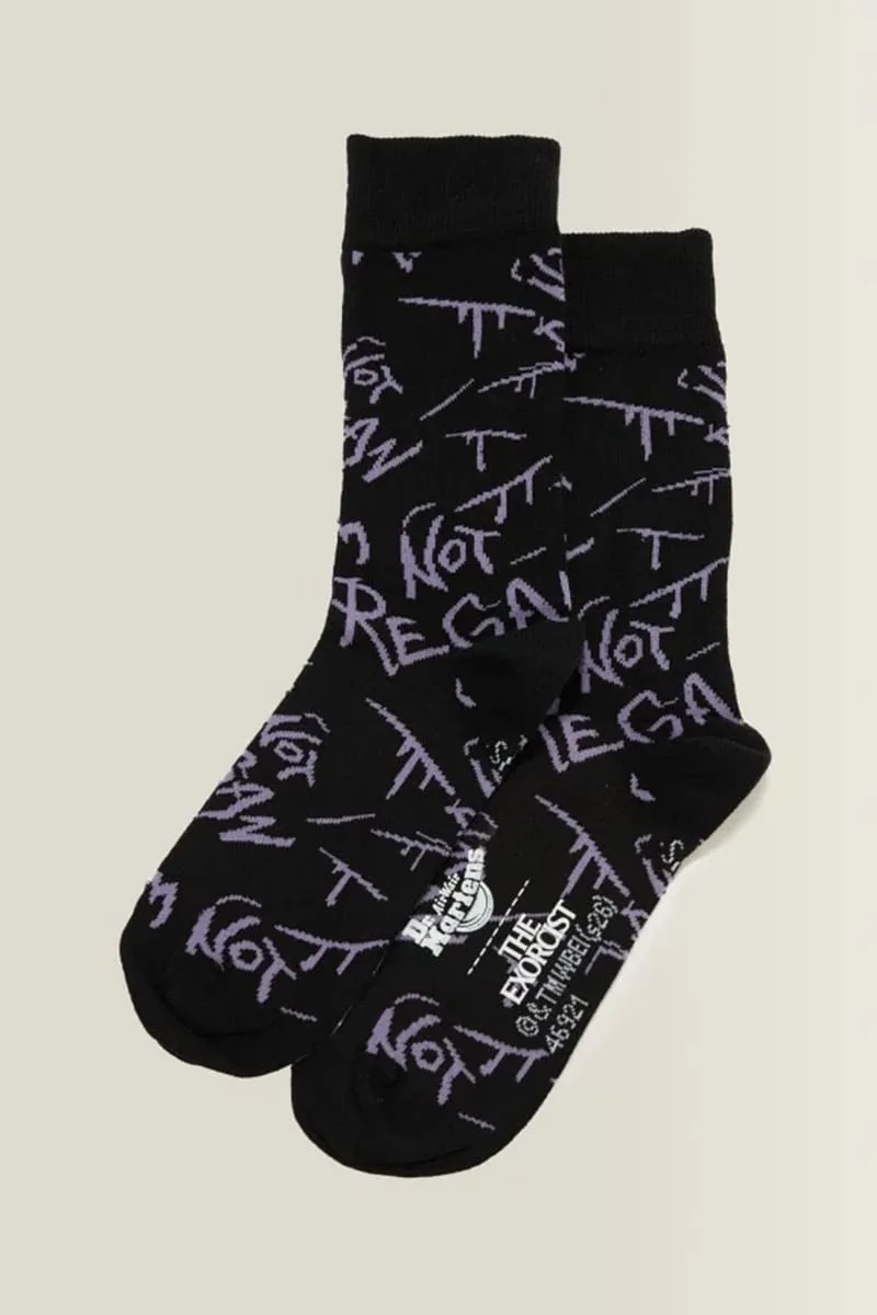 Top-down pair of black socks with purple scrawled lettering and Dr. Martens and The Exorcist text, The Exorcist