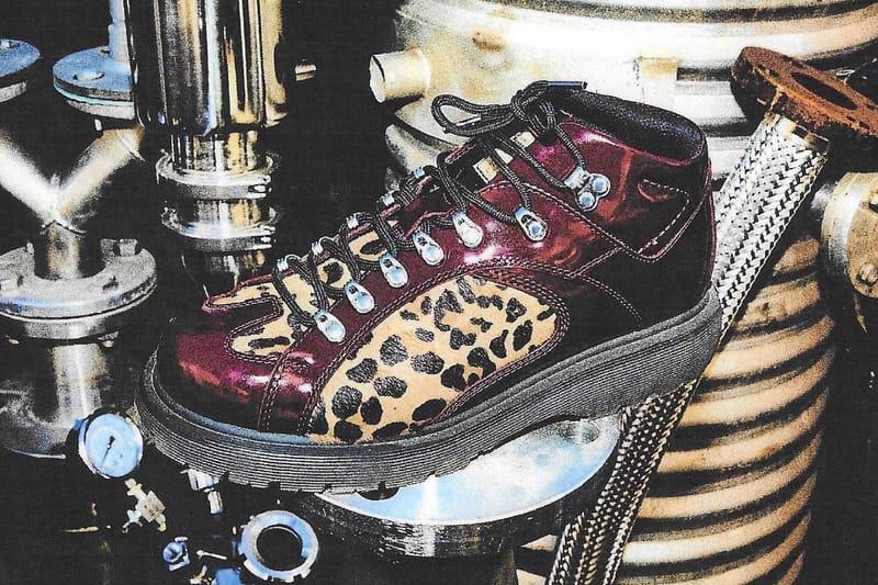 Lateral view of glossy burgundy boot with leopard-print panel, on metal industrial pipes, x Brain Dead