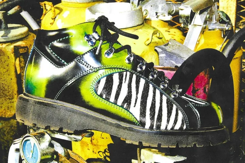 Lateral view of green and black boot with zebra-print panel, against yellow gas cylinders, x Brain Dead