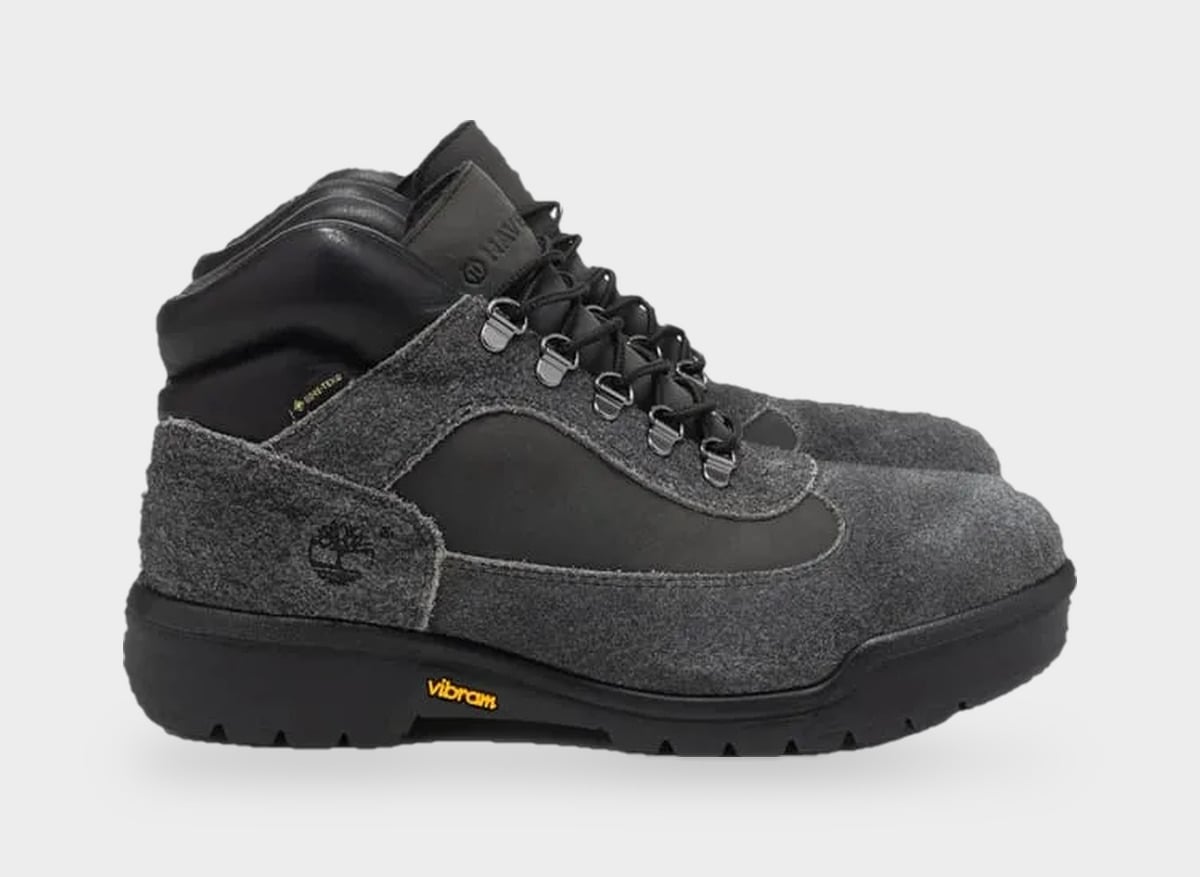 Lateral view of grey suede boot with black panel, silver eyelets, yellow Vibram logo, Black