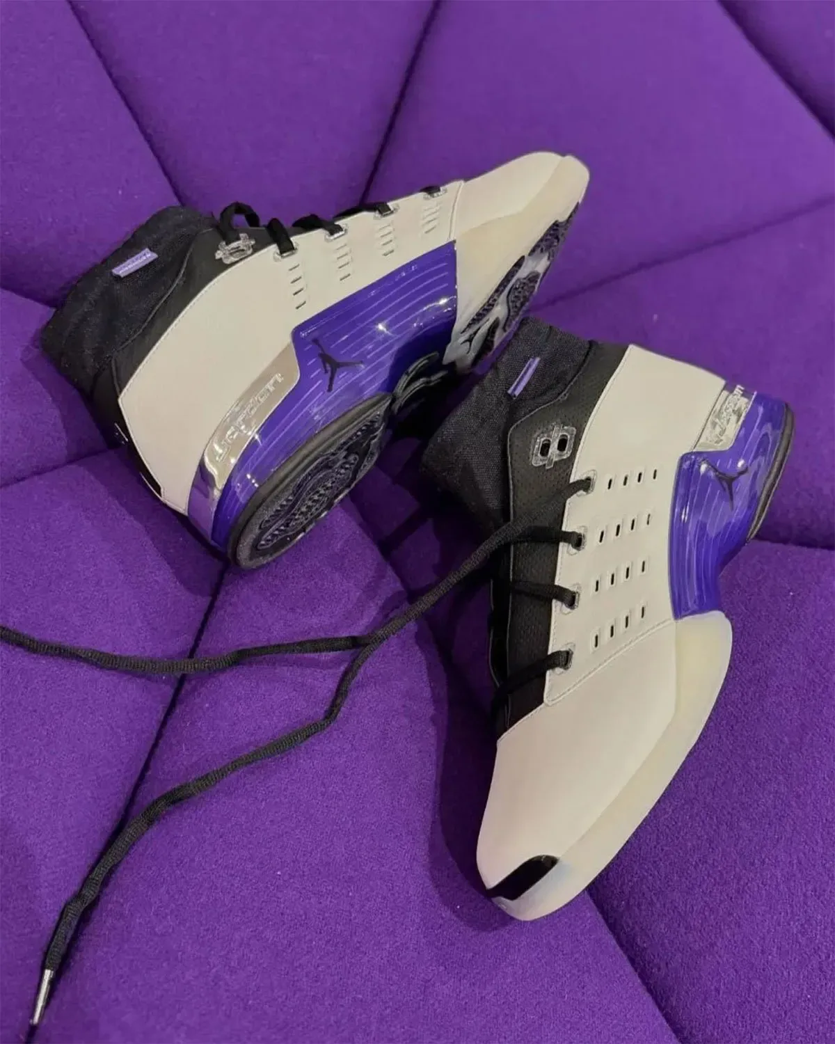 Pair on purple tufted surface, white and black uppers, purple translucent heel unit, long black laces, Varsity Purple