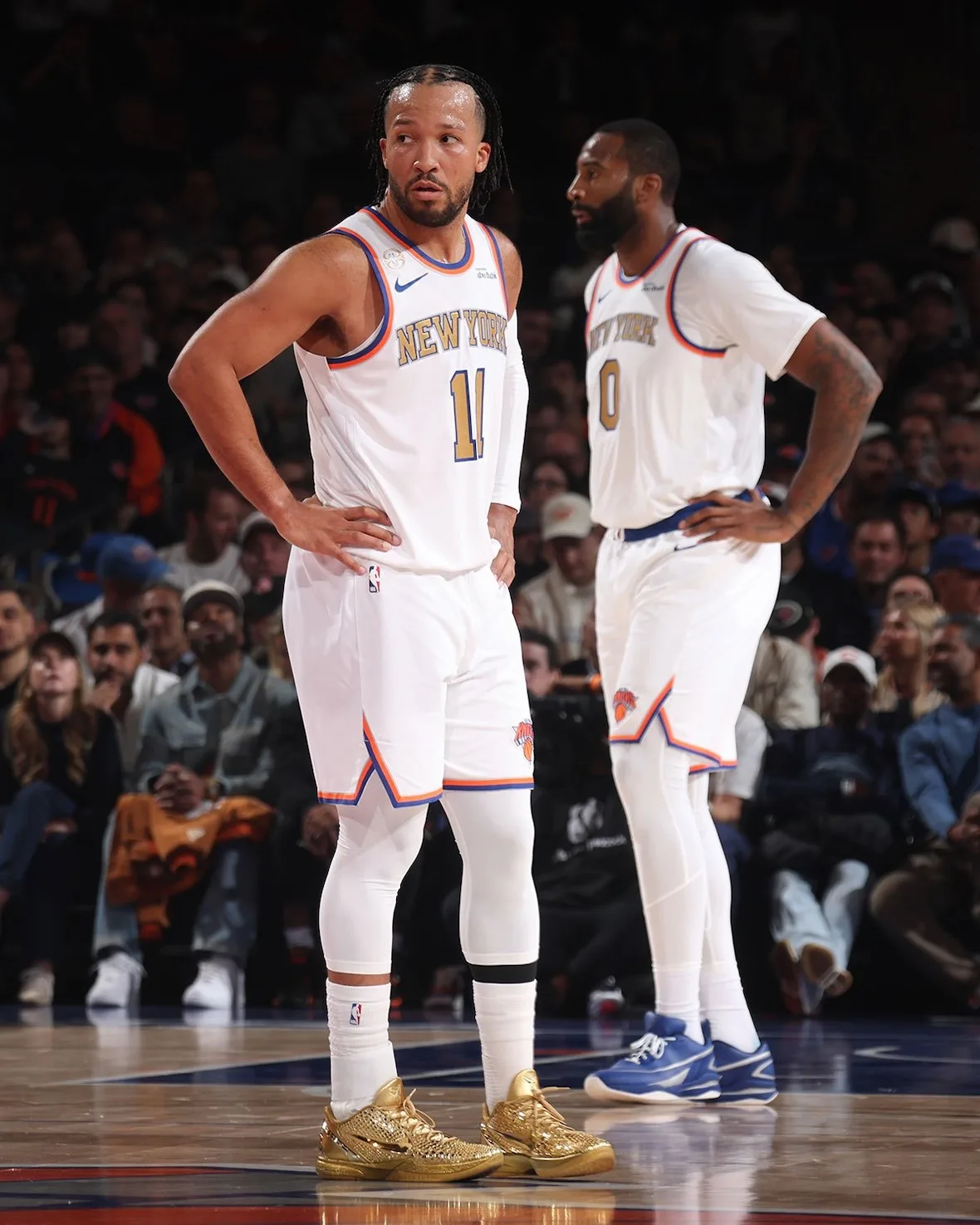 Two New York players on court, #11 in gold shoes with hands on hips and #0 in blue shoes behind, Ring Night