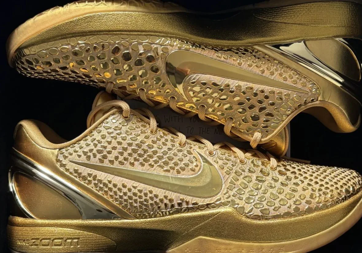 Pair in a dark box, one lateral and one medial, gold textured overlays, mirrored swoosh and ZOOM text, Ring Night