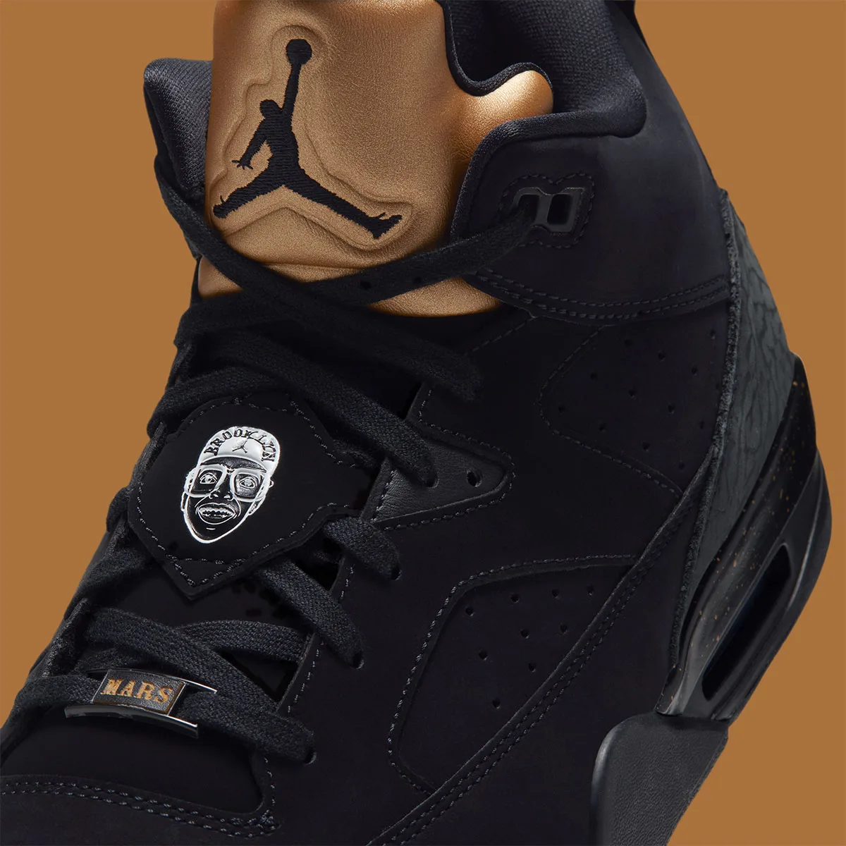 Detail of silver Brooklyn face badge, MARS lace tag and black Jumpman on gold tongue, Gold Tongue
