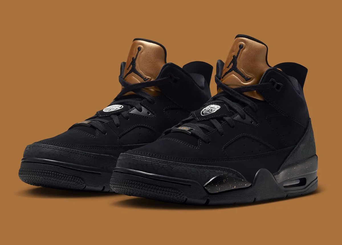 Pair, front three-quarter view, black suede uppers, gold Jumpman tongues, tan background, Gold Tongue