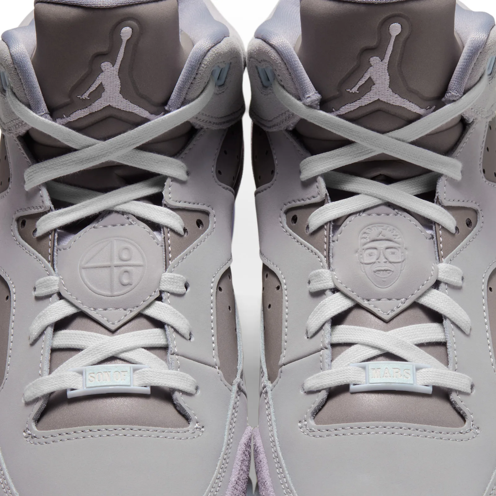 Close-up of laces on both shoes, embossed face and circle on lace panels, Son of Mars lace locks, Lunar Tunes