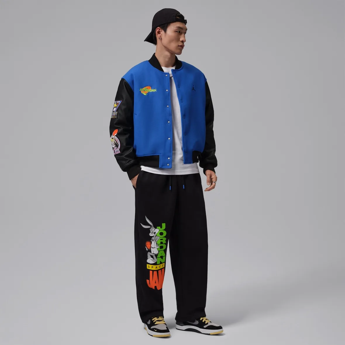 Full-body on-model view of blue and black varsity jacket with black pants and sneakers, Varsity Royal/Black