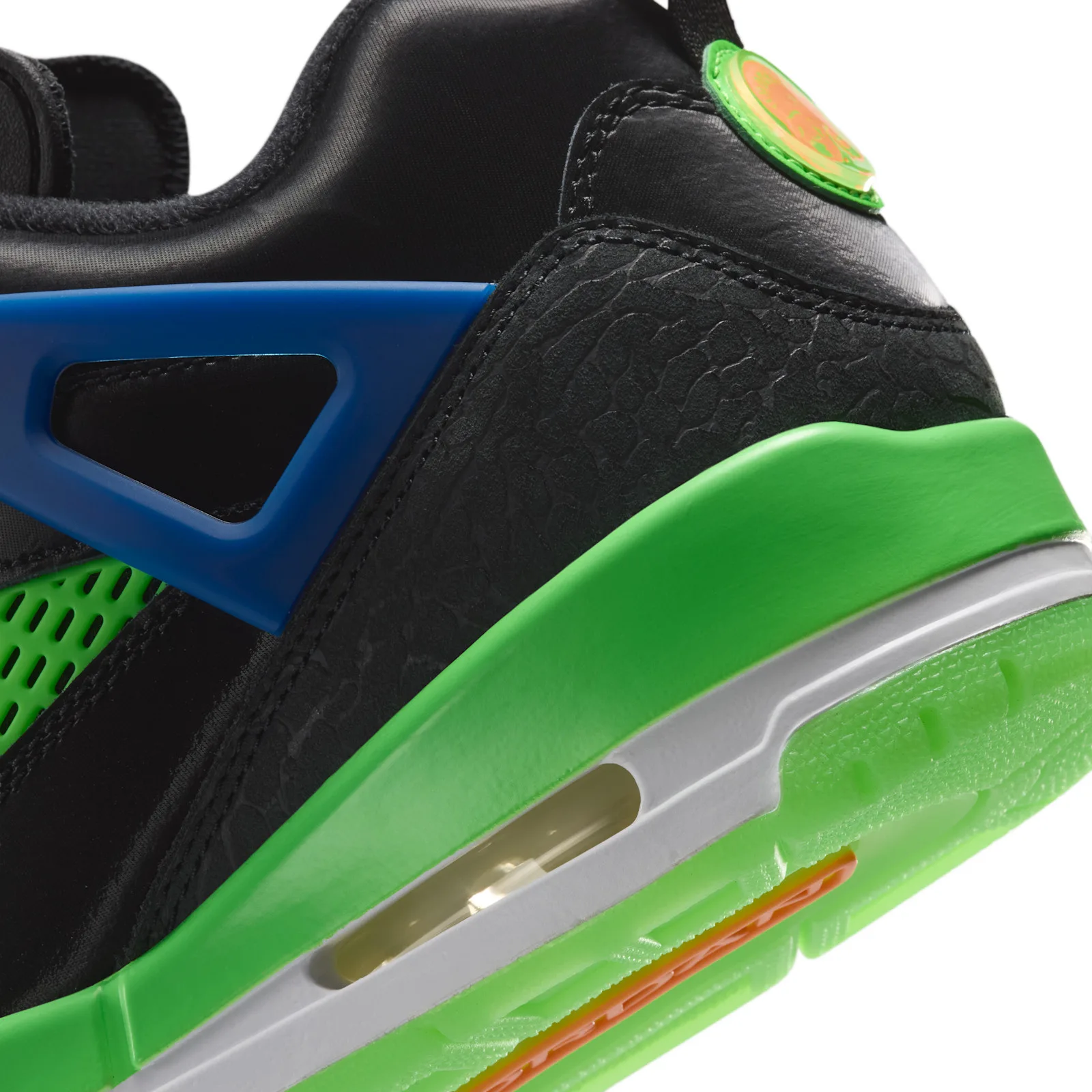 Detail of heel, blue cage, textured black overlay, round green badge and neon green midsole with air window, Space Jam
