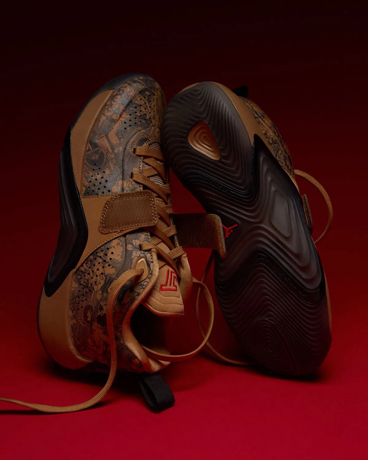 Pair standing on end, tan floral upper beside a dark ridged outsole with red Jumpman, red backdrop, Laser