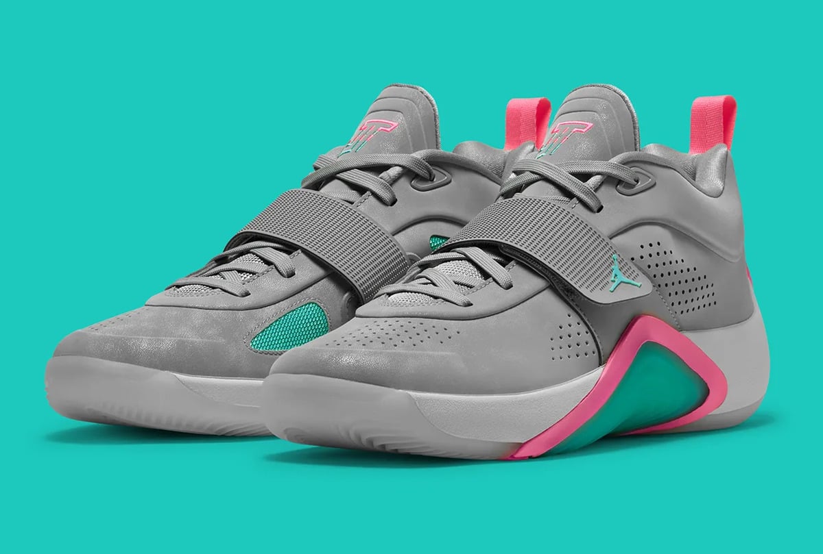Pair at three-quarter angle, grey straps, pink heel tabs, teal mesh panels, teal background, South Beach
