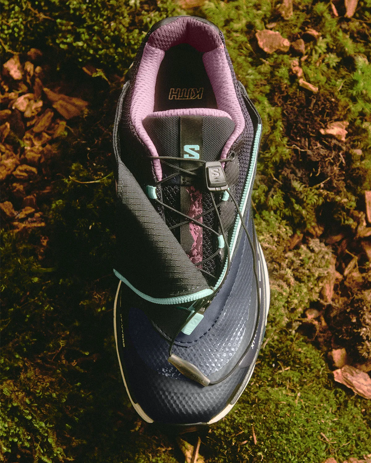 Top-down view of a navy shoe with mint zip and purple lining on moss, Winter 2026 Collection