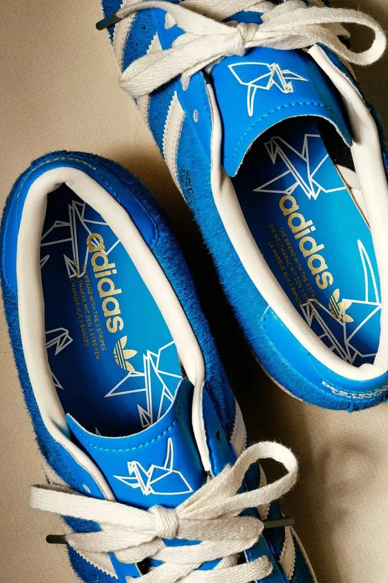 Detail of insoles with gold adidas text and origami crane print, crane logo on tongues, Blue
