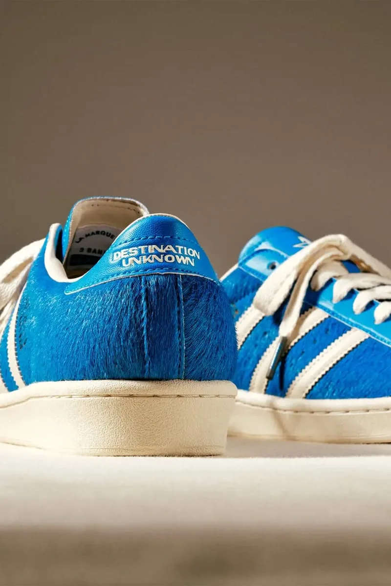 Heel view of blue hairy upper with 'Destination Unknown' heel tab, second shoe behind, Blue
