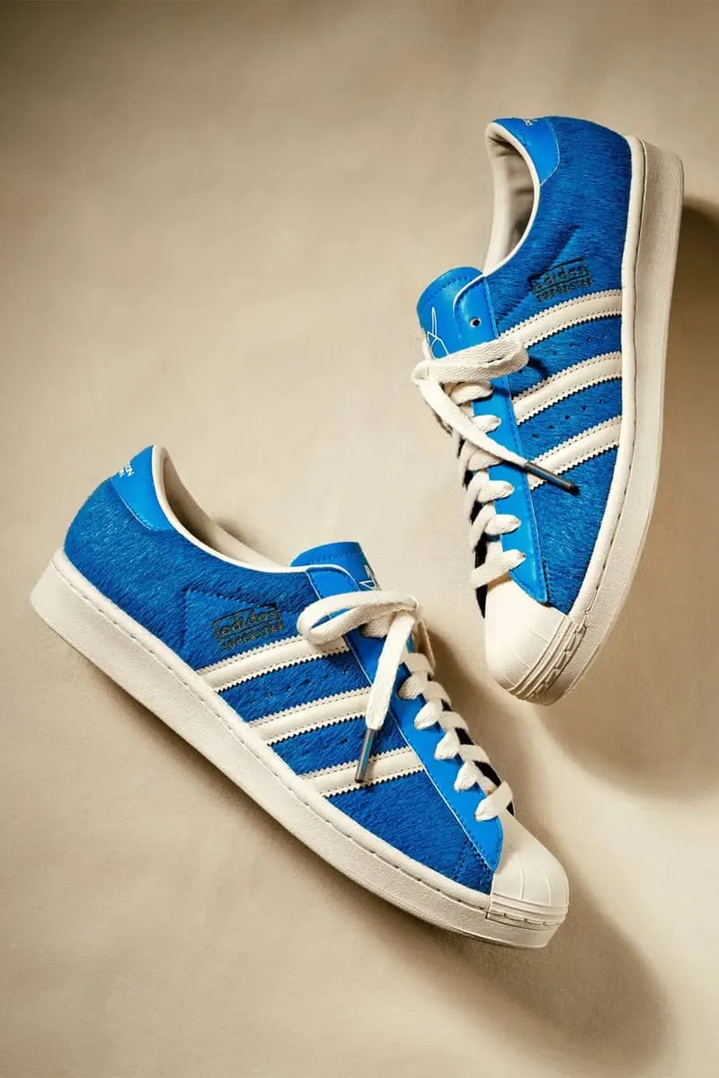 Pair from above on beige backdrop, blue hairy upper, cream stripes, shell toe and laces, Blue