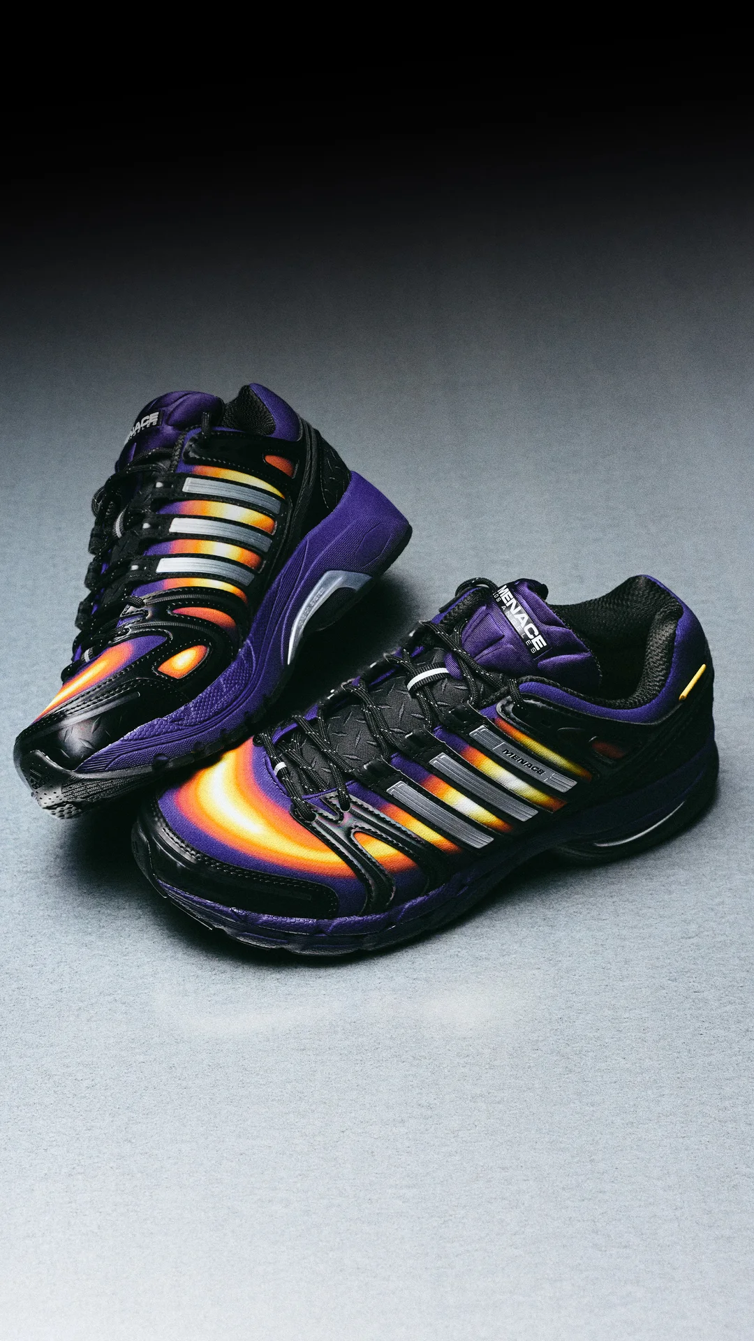 Front three-quarter view of the pair with yellow-to-red heat map panels, silver stripes and purple midsoles