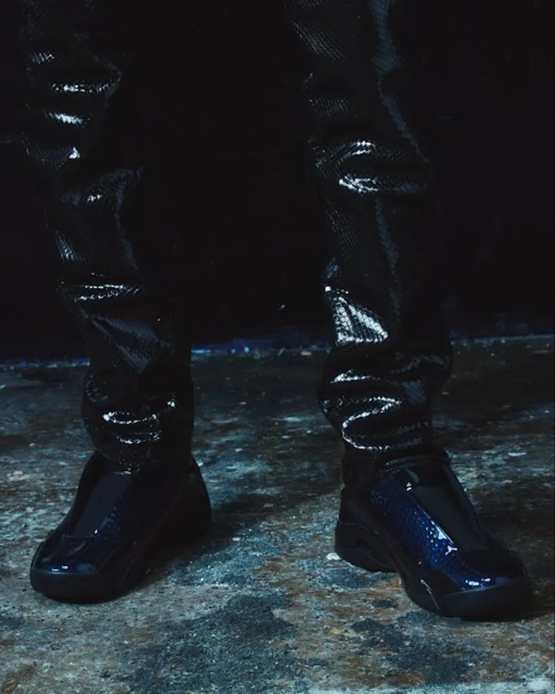 On-foot pair in dark setting, glossy navy croc-embossed uppers with black soles and shiny trousers, Patent Croc