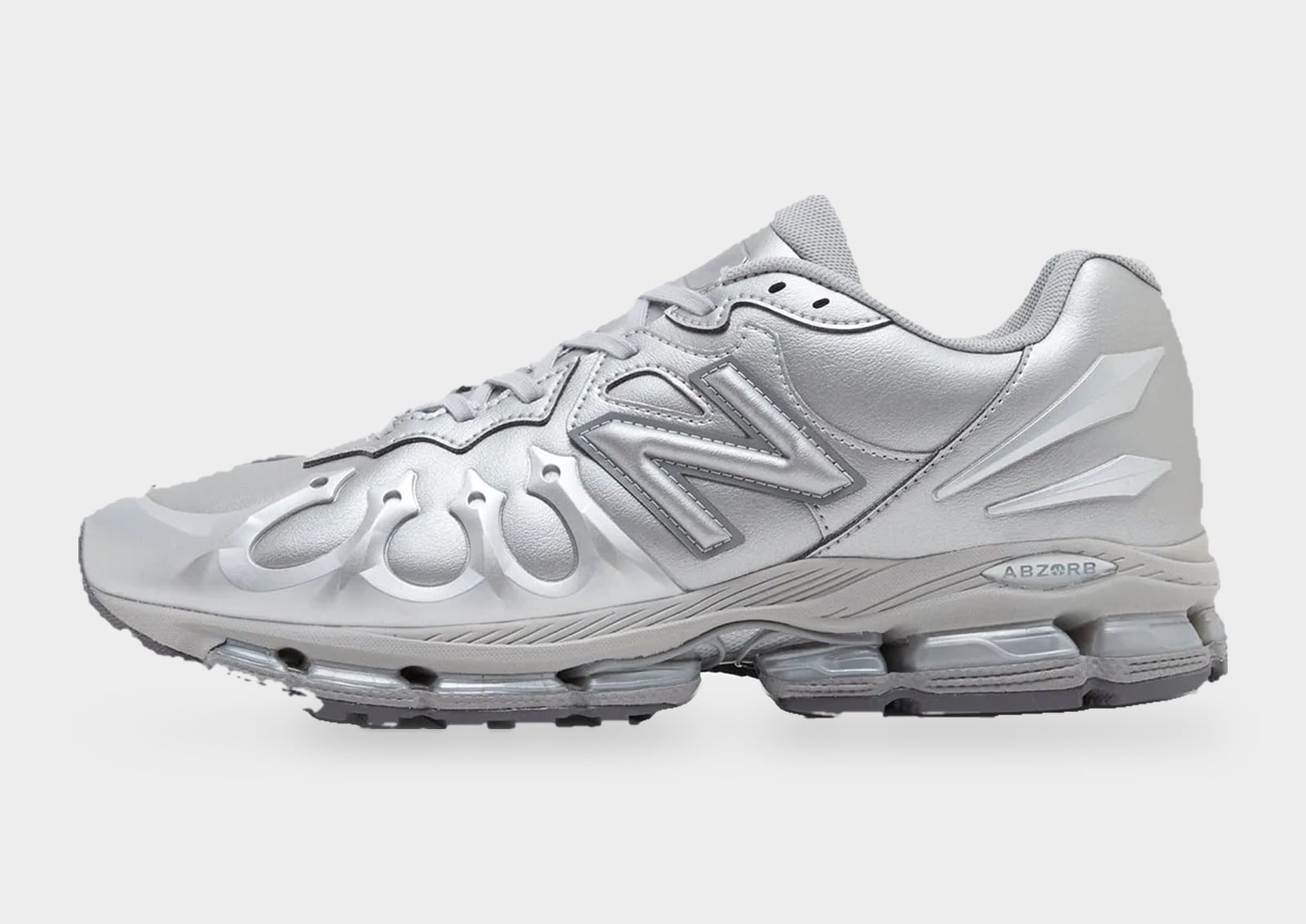 Lateral view of a metallic silver sneaker with flame-shaped toe overlays and large N logo, New Balance 1890 “Liquid Metal”