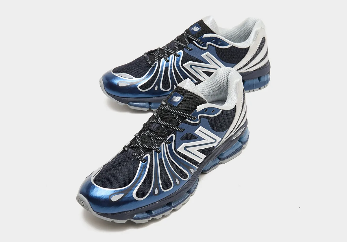 Pair at an angle, glossy blue toe caps, black mesh, silver N logos and speckled black laces, Metallic Blue